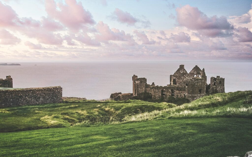 gray concrete castle on green grass field near body of water during daytime